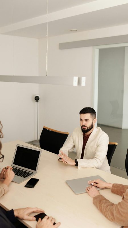 A diverse group engaged in a business meeting in a modern office setting.